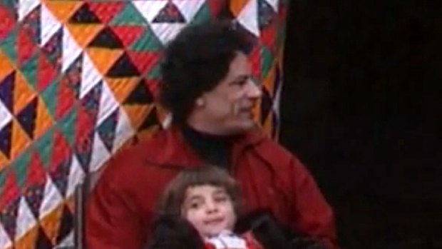 A screenshot from the video showing Muammar Gaddafi cuddling a girl identified as his daughter, 'Hana'.