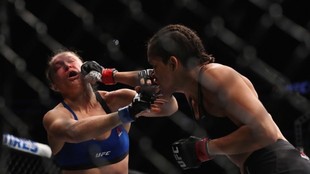 Brazilian Amanda Nunes punches Ronda Rousey in their UFC women's bantamweight championship bout.