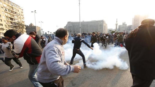 Anti-government protesters scatter after police fired tear gas at them during a demonstration in downtown Cairo.