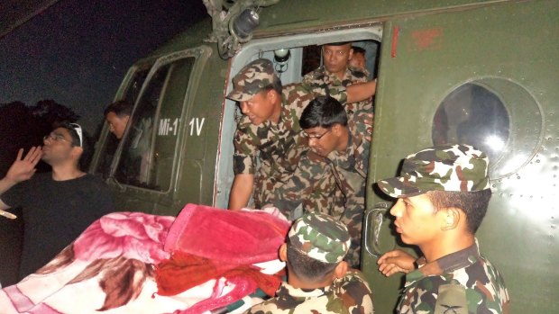 An injured survivor of the snowstorm is lifted onto the Nepalese Army helicopter on the Annapurna Circuit hiking trail.