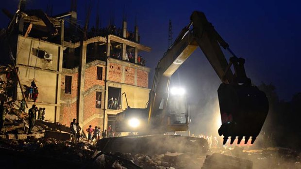 An excavator removes debris as volunteers and rescue workers search the site of a garment factory complex in Bangladesh, which collapsed on April 24.