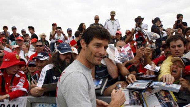 Australian driver Mark Webber signs autographs for fans at the Australian Formula One Grand Prix at Melbourne's Albert Park earlier this year.