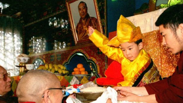 Homage ...  Gyaltsen Norbu, installed as the 11th Panchen Lama, is handed rice.