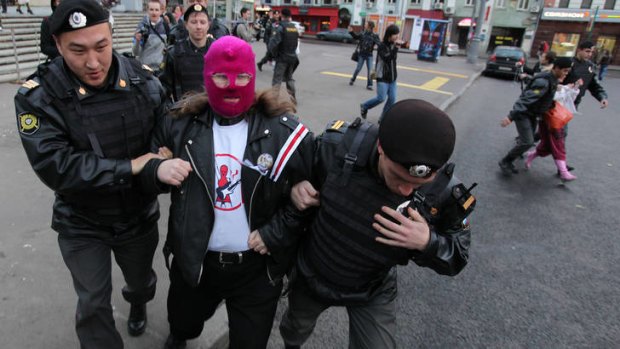 Birthday wishes ... police detain a man wearing a Pussy Riot balaclava as demonstrators in Moscow called for Vladimir Putin to retire on his 60th birthday.