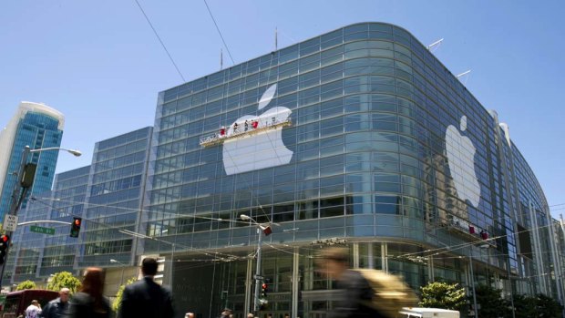 Workers apply Apple logo to the exterior of the Moscone West Center in San Francisco ahead of Apple's annual Worldwide Developers Conference.