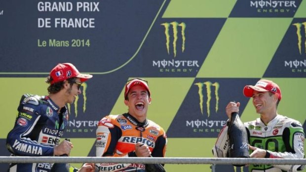 Marc Marquez of Spain (centre - winner), Valentino Rossi of Italy (left - second), and Alvaro Bautista of Spain (third) spray champagne on the podium after the French Grand Prix at the Le Mans circuit on Sunday.