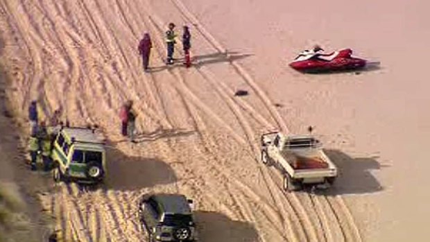 Emergency workers speak with witnesses on the beach. <i>Channel Ten</i>
