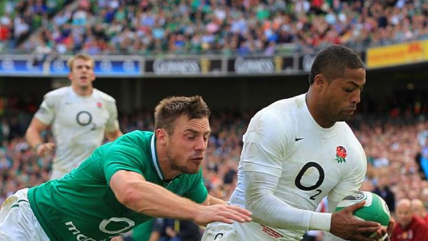 England's Delon Armitage scores a try despite pressure from Ireland winger Tommy Bowe.