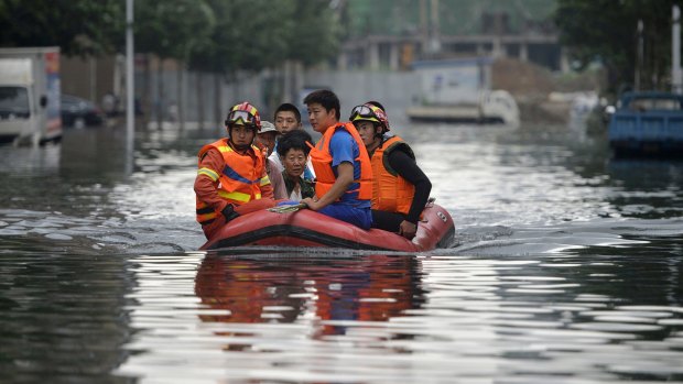 Rescuers use a raft to transport people along a flooded street in Shenyang in north-eastern China's Liaoning Province.  