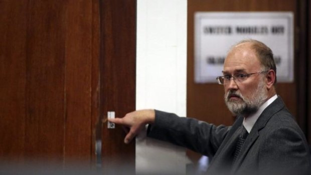Forensic expert Roger Dixon points at the door through which Reeva Steenkamp was shot by Oscar Pistorius.