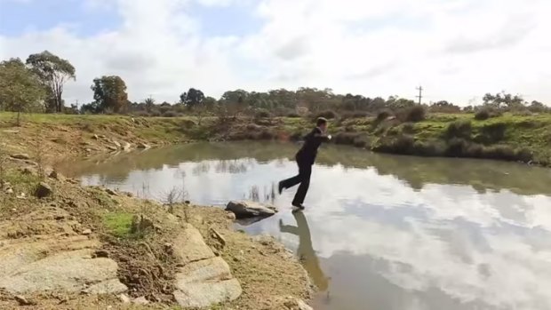 In the first video, a man jumps into a dam fully clothed.