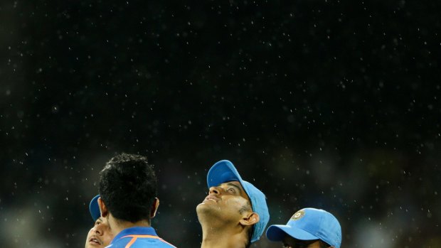 India's Mahendra Singh Dhoni looks to the heavens as rain starts to fall during the Australian innings in Chennai on Sunday.