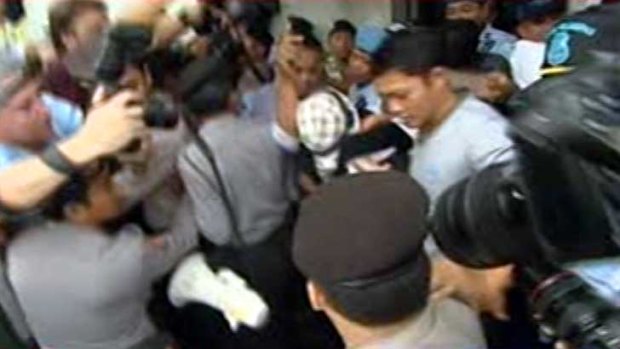 Schapelle Corby, wearing a checked hat, leaves Kerobokan prison.