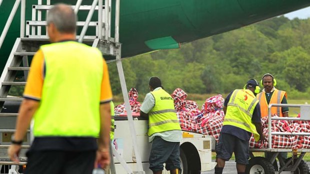 Getting a load: Cargo is handled in Papua New Guinea from the second plane of asylum seekers sent to Manus Island.