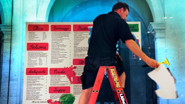 Restaurant Giuseppe Arnaldo & Sons' menu being removed from a wall inside the Crown complex.