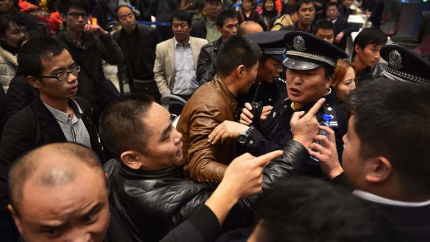 Stranded travellers arguing with police and airline personnel at Changshui International Airport in Kunming, after massive flight delays hit the airport and stranded thousands.