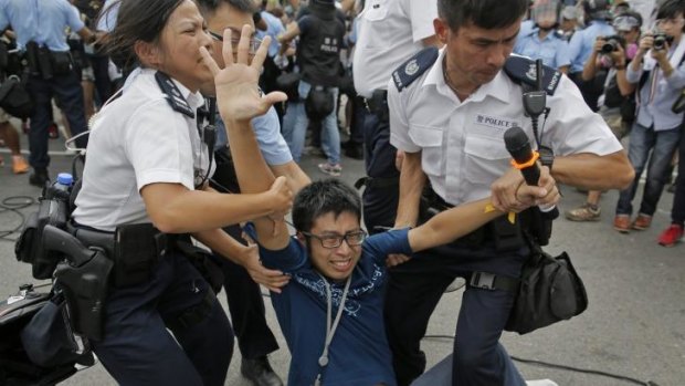 A pro-democracy protester is taken away by police officers in Hong Kong.