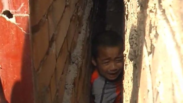 Trapped ... Chinese rescuers had to inflate a matress to free this boy.