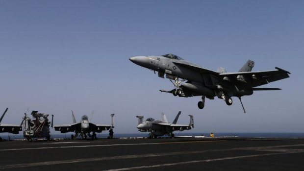 Air strikes but 'no boots on the ground' ... An F/A-18E Super Hornet lands on the flight deck of the aircraft carrier USS George H.W. Bush in the Persian Gulf.