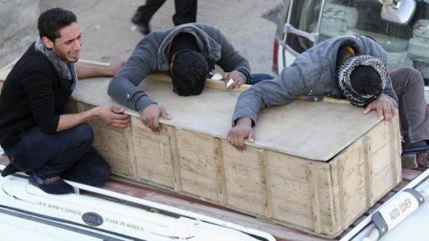 Mourners hold on to the coffin of an Iraqi killed in an attack on pilgrims near Baghdad.