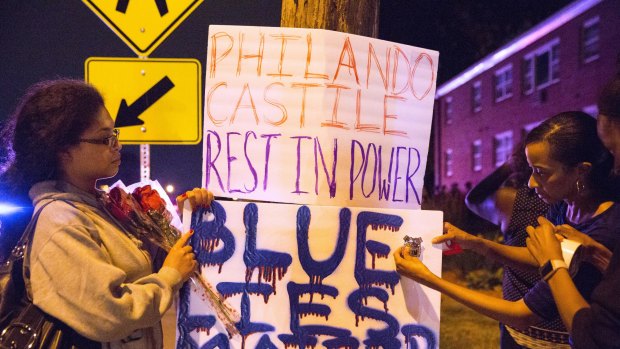 Protesters hang signs near the scene of Philando Castile's shooting.
