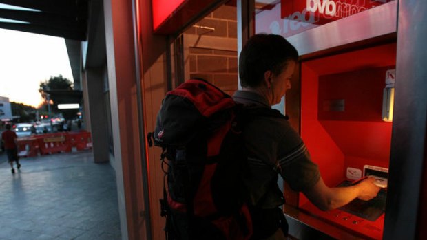 Matthew Reid collects his rented DVD from a DVD vending machine at RedroomDVD in Bondi Junction.