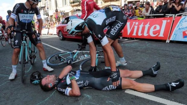 Ouch: Mark Cavendish clutches at his shoulder after dislocating his collarbone.