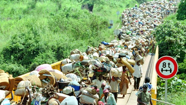Refugees cross the Rwanda-Tanzania border on their way home from exile in Tanzania, where they fled following genocide in Rwanda. Australia has contributed to an international tribunal prosecuting the perpetrators, but its domestic laws treat the issue differently.