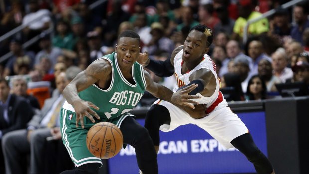 At close quarters: Atlanta Hawks guard Dennis Schroeder reaches in to try to steal the ball from Boston Celtics rival Terry Rozier.
