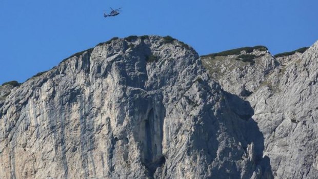 A helicopter flies above the Berchtesgaden Alps, where rescuers were working Monday to recover a man stuck deep inside a cave.