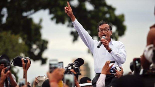 Sam Rainsy, president of the opposition Cambodia National Rescue Party (CNRP), speaks to his supporters after his supporters clashed with policemen, near the Royal Palace in central Phnom Penh September 15, 2013.