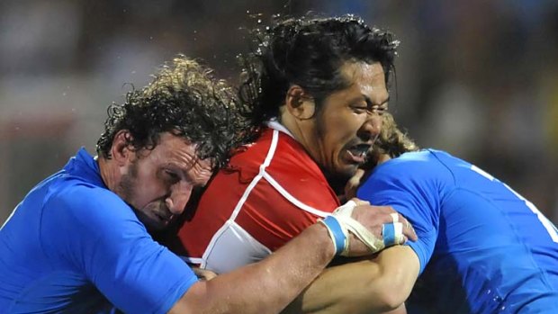 Crunched ... Kosuke Endo of Japan is tackled by Mauro Bergamasco (l).