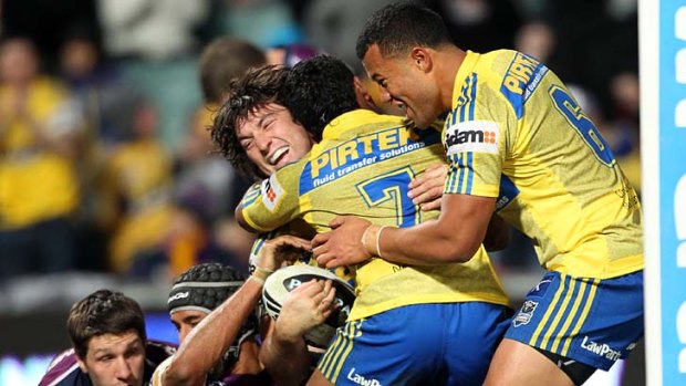 Something to cheer about ... Eels players embrace Nathan Hindmarsh after his try seals their upset win over the fancied Storm.