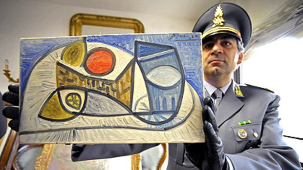 An Italian tax police officers holds a Picasso painting, one of the 19 artworks seized from the home of Parmalat founder Calisto Tanzi.