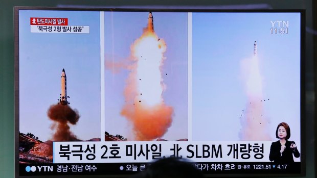 A man in South Korea watches a news program showing photos published in North Korea's Rodong Sinmun newspaper of North Korea's Pukguksong-2 missile launch last month.