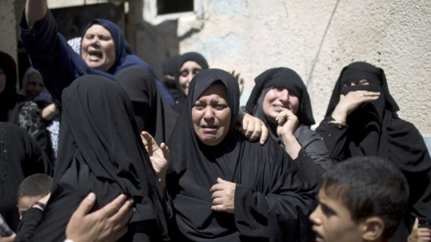 Relatives of senior Hamas commander Raed al-Atar mourn during his funeral.