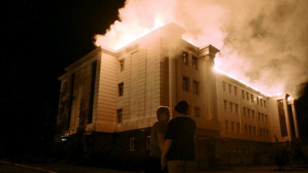 Bystanders watch a fire consuming a school in Donetsk.
