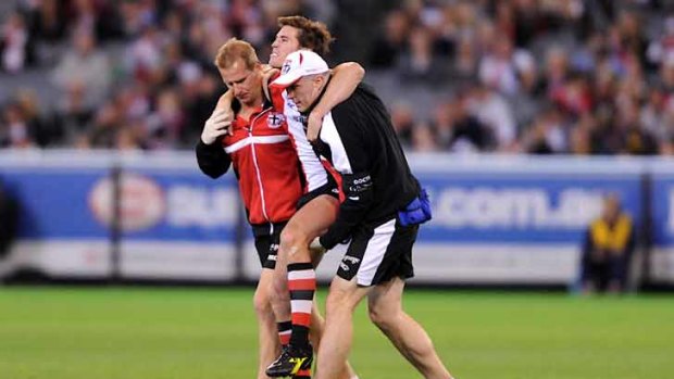 Saints star Lenny Hayes is helped off after injuring his knee in last night's clash with Richmond at the MCG.