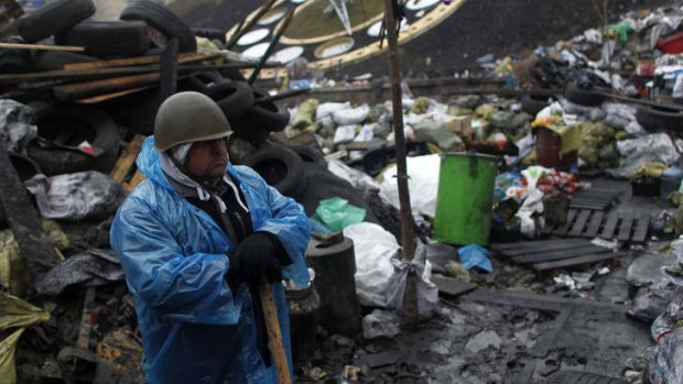 On the front line: A protester stands guard on a barricade in Independence Square in Kiev.