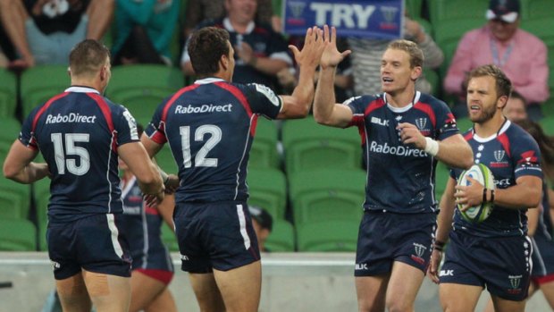 High fives: The Rebels celebrate a try.