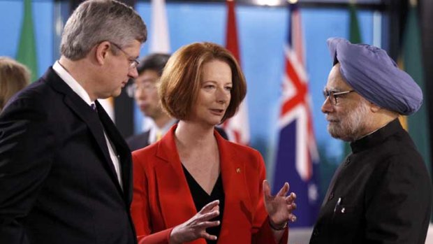 Julia Gillard speaks with Canada's Prime Minister Stephen Harper (left) and India's PM Manmohan Singh at the G20 Summit in Cannes.
