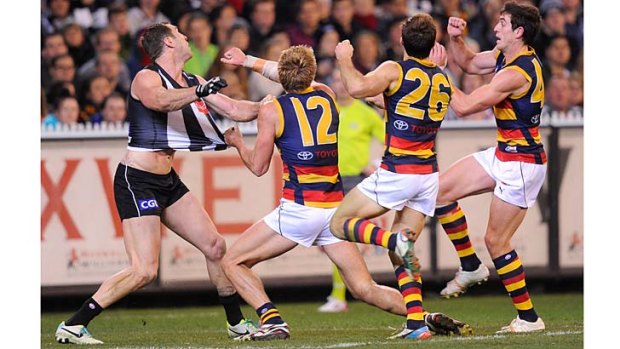 Beating the odds: Magpie Travis Cloke marked in this contest against Crows Daniel Talia, Richard Douglas and Ricky Henderson at the MCG on Friday night.