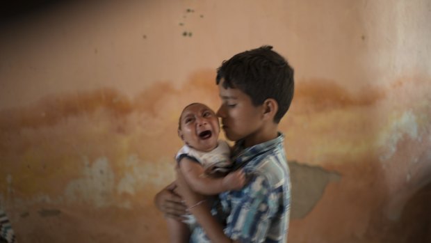 Ten-year-old Elison nurses his 2-month-old brother Jose Wesley, who was born with microcephaly, at their house in Brazil. 