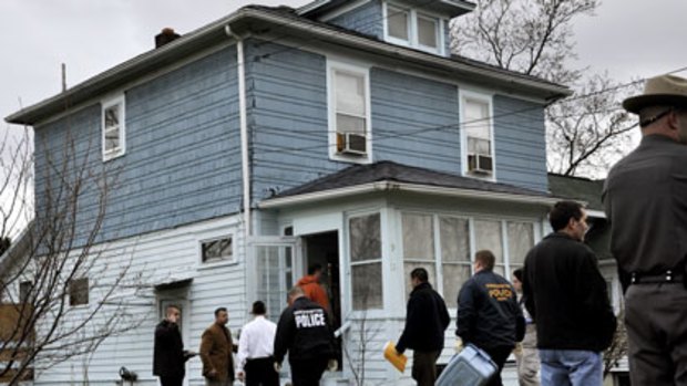 Authorities enter a Johnson City, NY home belonging to Jiverly Voong,the suspected gunman in the shootings.