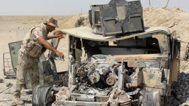 The wreckage of a Humvee belonging to Islamic State militants lies along a road after it was targeted by Iraqi security forces.
