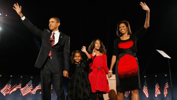 US President-elect Barack Obama with wife Michelle - in that dress - and daughters Malia (red dress) and Sasha (black dress) during an election night gathering.