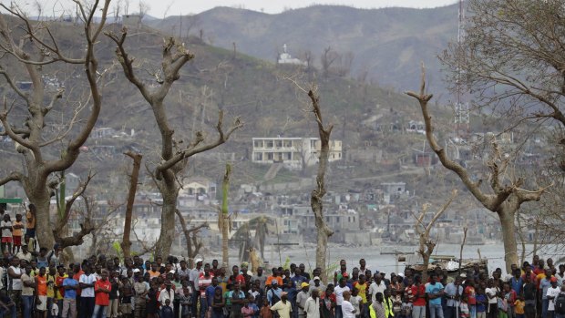 Haitians, hard hit by Hurricane Matthew, await aid from a US helicopter earlier this month.