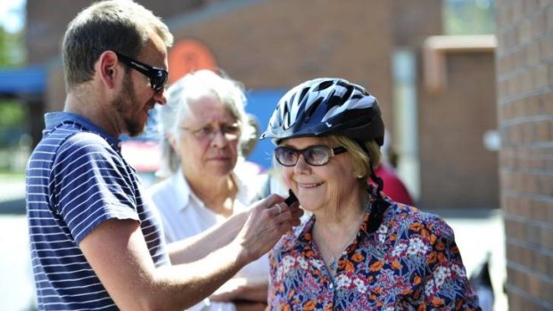 Carol Walker of Kingston has a helmet fitted by Pedal Power project manager, Stuart Jones during Pedal Power ACT's "Come n Try Day" at Melrose High School.