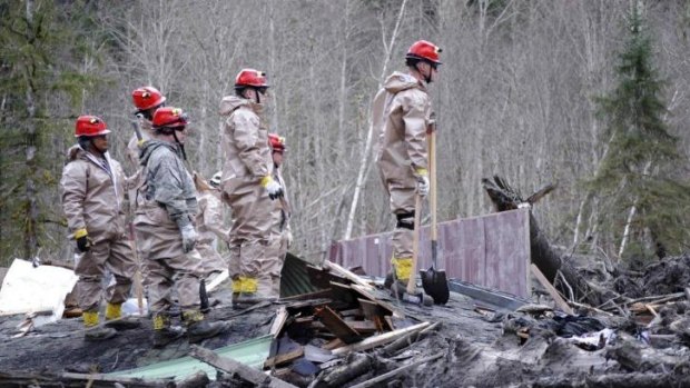 Air Force personnel join civilian workers in efforts to find missing persons following a deadly mudslide in Oso, Washington.