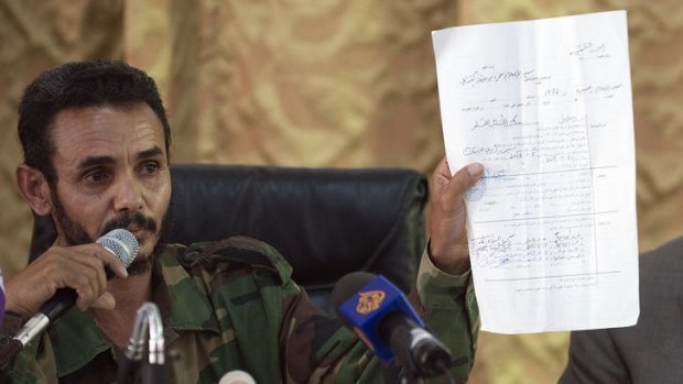 Ajmi al-Atiri, commander of the Zintan brigade that arrestedf Seif al-Islam, the detained son of slain leader Muammar Gaddafi, shows a document during a press conference in the Libyan city of Zintan.